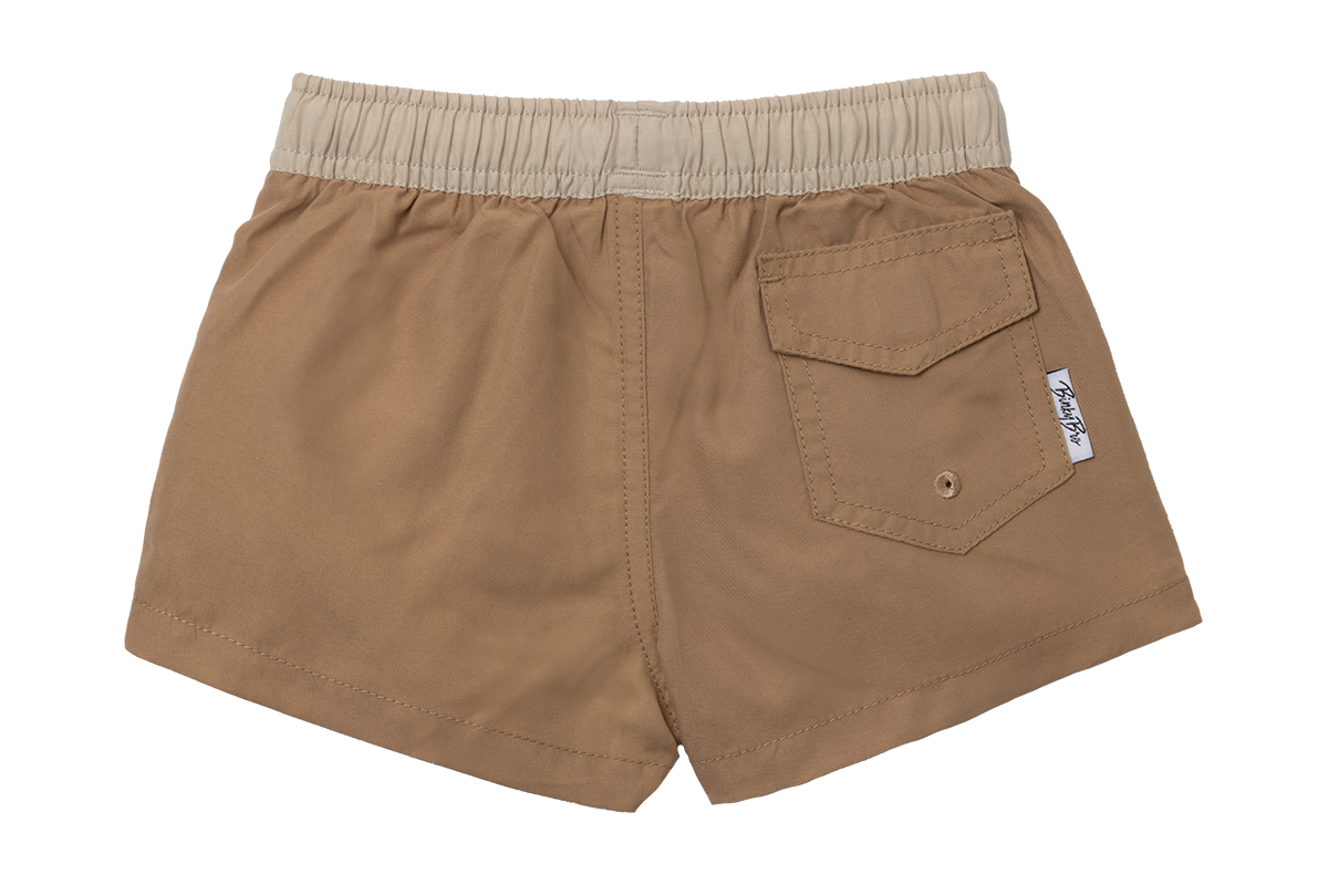 Bula Bowls Swimmie in tan with an elastic waistband and back pocket, designed for stylish comfort in water activities.