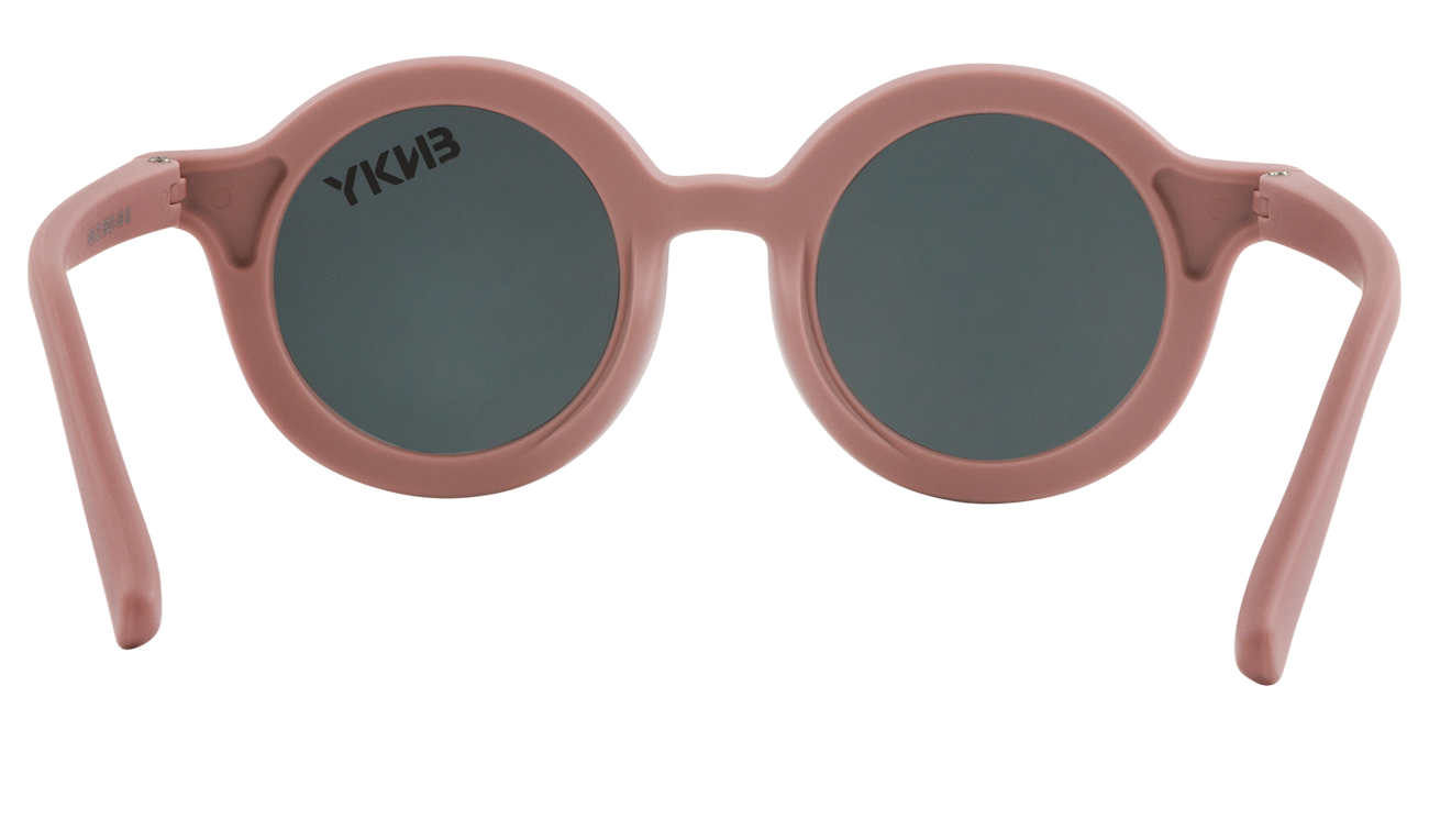 Round vintage sunglasses with a soft pink frame and dark lenses, featuring the brand logo on the left arm.