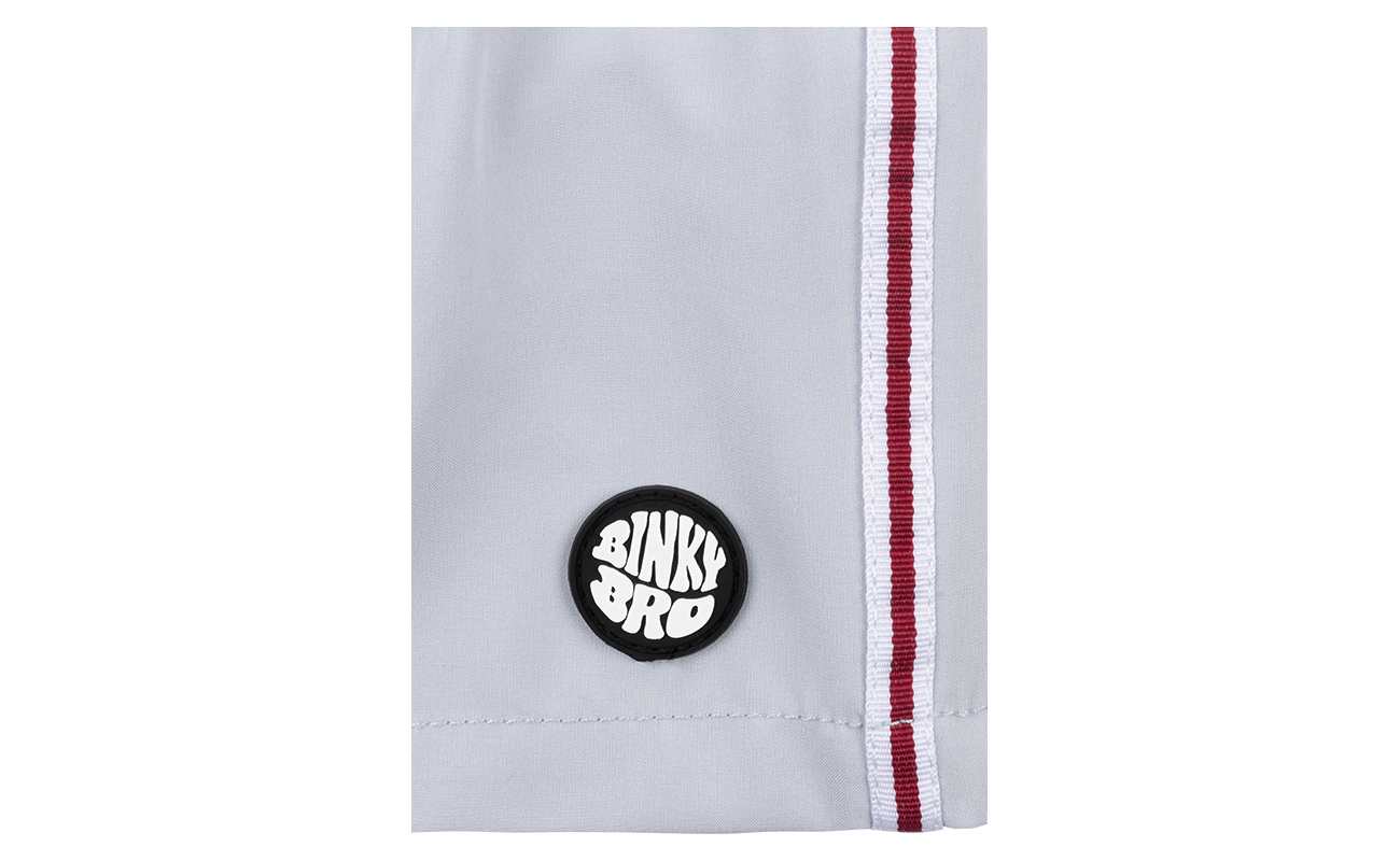 Close-up of a light gray swim short featuring a BinkyBro logo patch and red side stripes, designed for kids.
