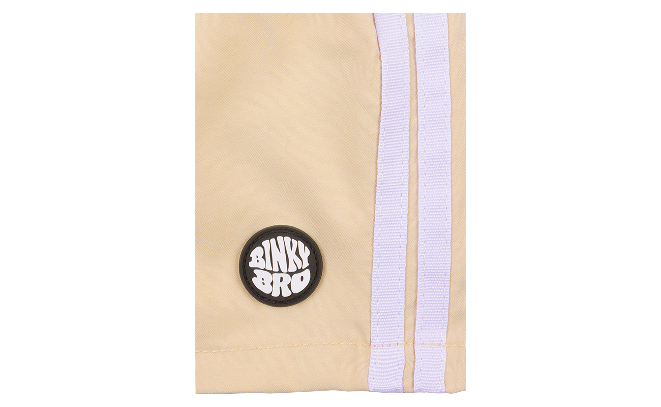 Close-up of the Teahupoo Swimmie featuring a BinkyBro logo patch and stylish side stripes in a soft beige color.