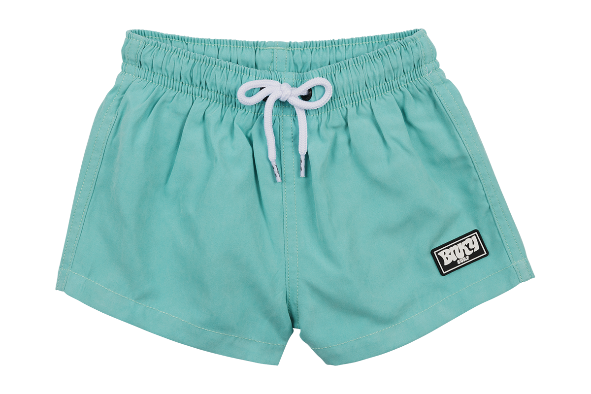 Teal and blue suede swim shorts with an elastic waistband and white drawstring, featuring a logo patch.