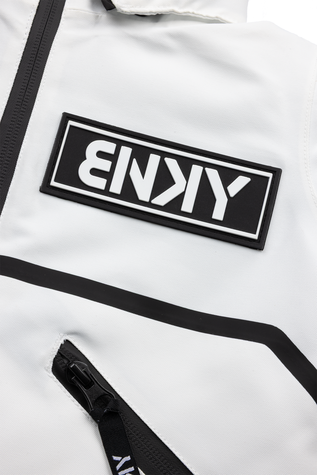 Close-up of the BNKY Stalactite jacket featuring a prominent black logo patch and sleek zipper detail on a white fabric.