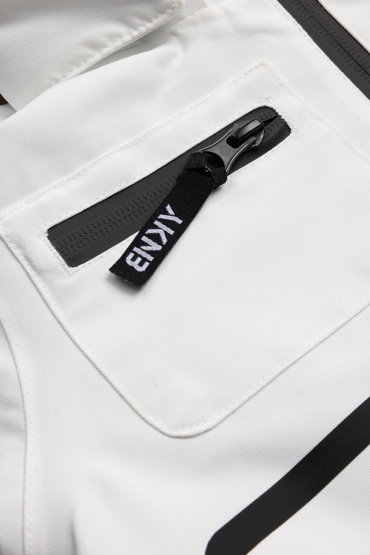 Close-up of the 99-90 BNKY Stalactite featuring a zippered pocket on a white fabric background, showcasing sleek design and functionality.