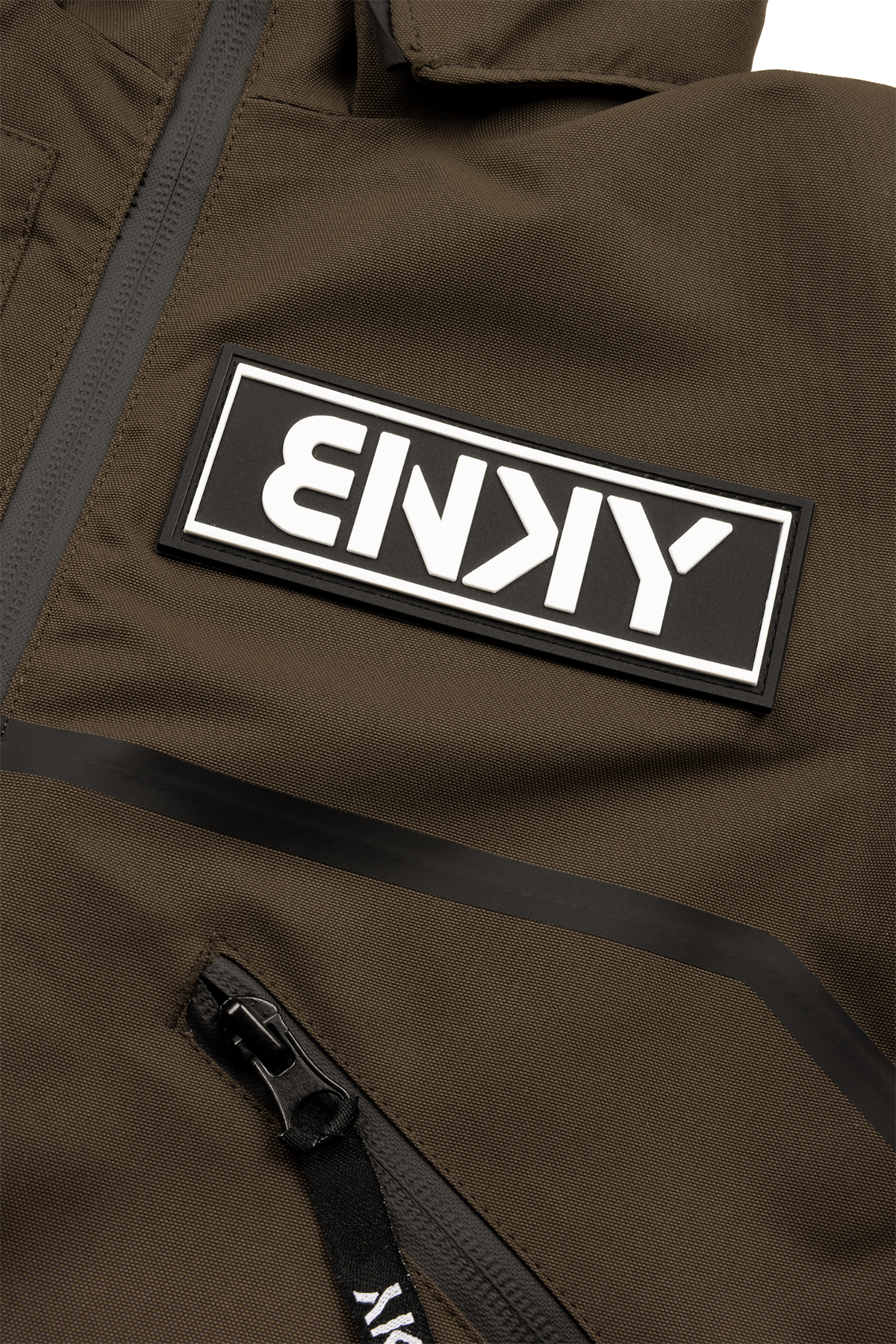 Close-up of a brown jacket featuring a prominent black and white BNKY logo patch and a zippered pocket.