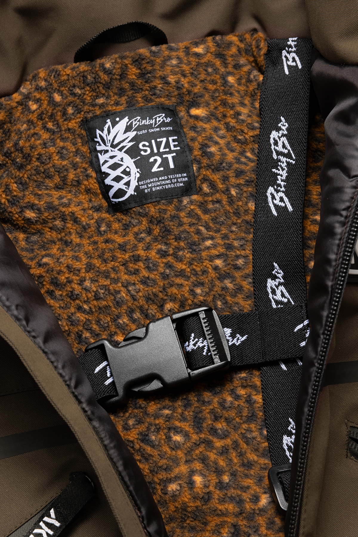 Interior view of the BNKY Chocolate jacket showing a soft, brown fleece lining and a size tag for 2T.