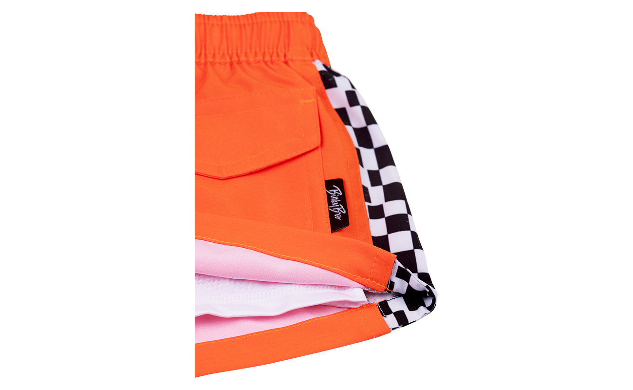 Bright orange Harada shorts featuring a checkered pattern on the inner lining, perfect for stylish, active kids.