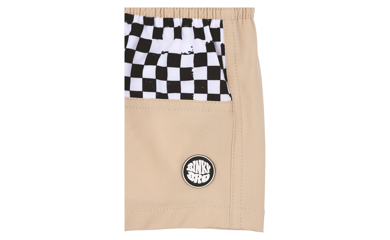 Beige shorts featuring a black and white checkered pocket and a BinkyBro logo, perfect for stylish kids.