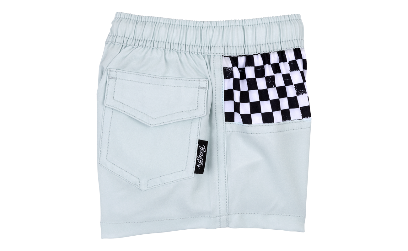 Light blue shorts featuring a black and white checkered pocket, designed for stylish kids' surf and skate wear.
