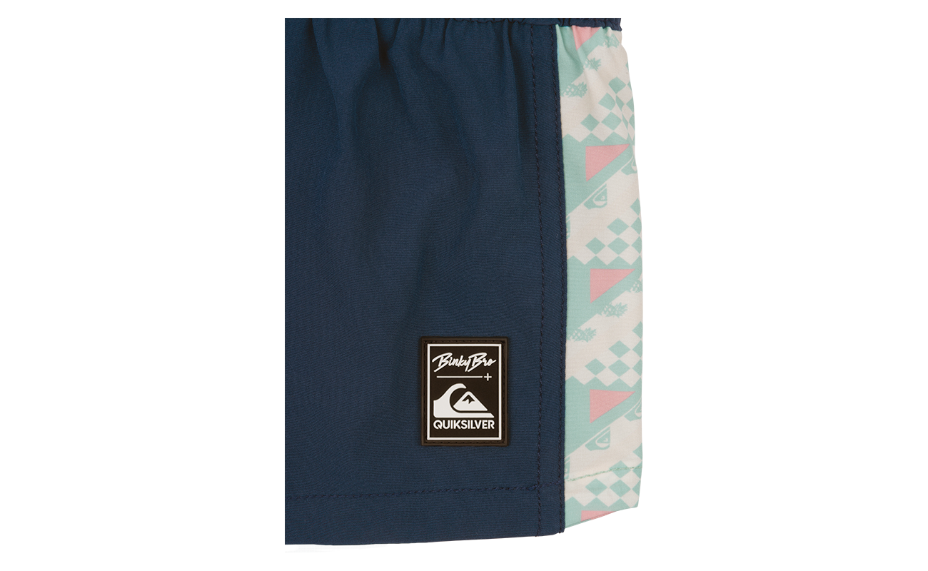 Stylish navy swim shorts featuring a colorful geometric print and BB x Quik branding, perfect for active kids.