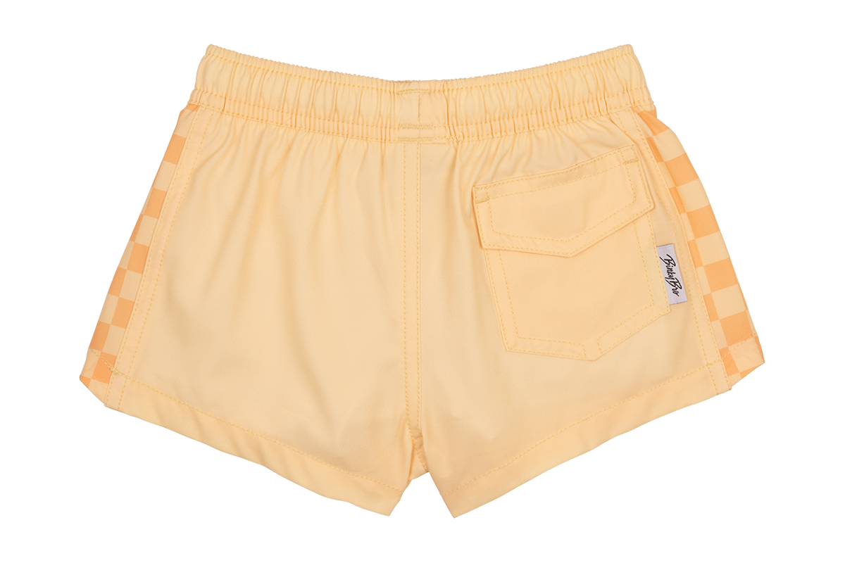 Peach-colored shorts featuring checkered side panels and a back pocket, designed for stylish kids' summer wear.