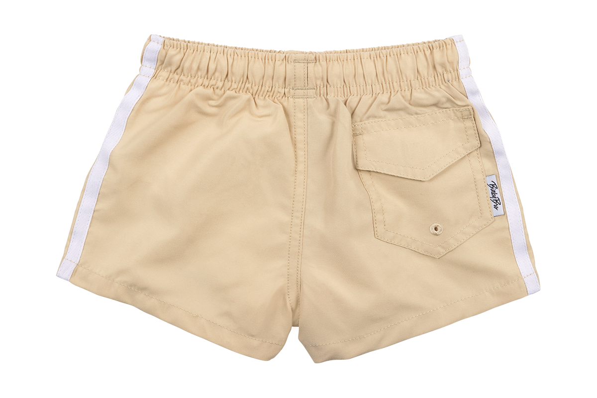 Tan swim shorts with white side stripes and a back pocket, designed for infants and toddlers, perfect for beach adventures.