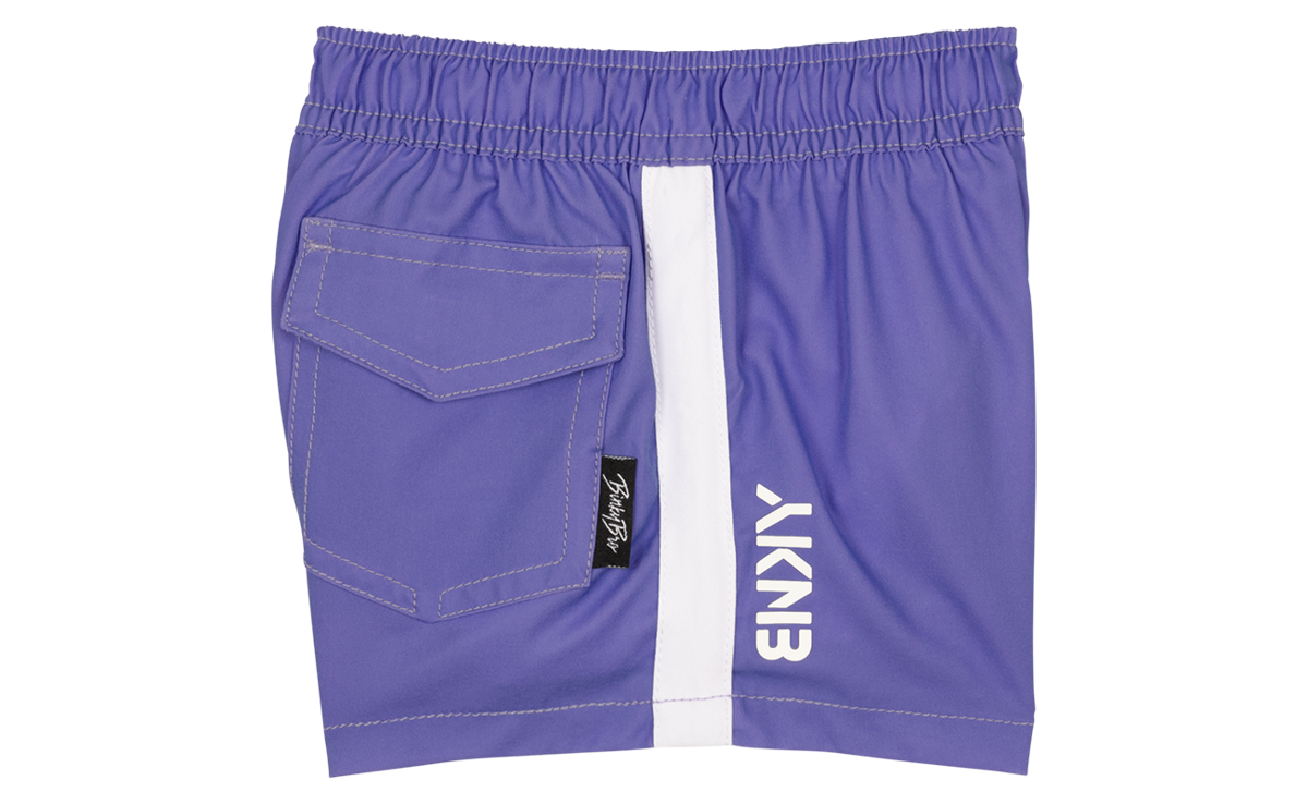 Stylish purple shorts featuring a side pocket and white stripe, perfect for active kids who love surf and skate culture.