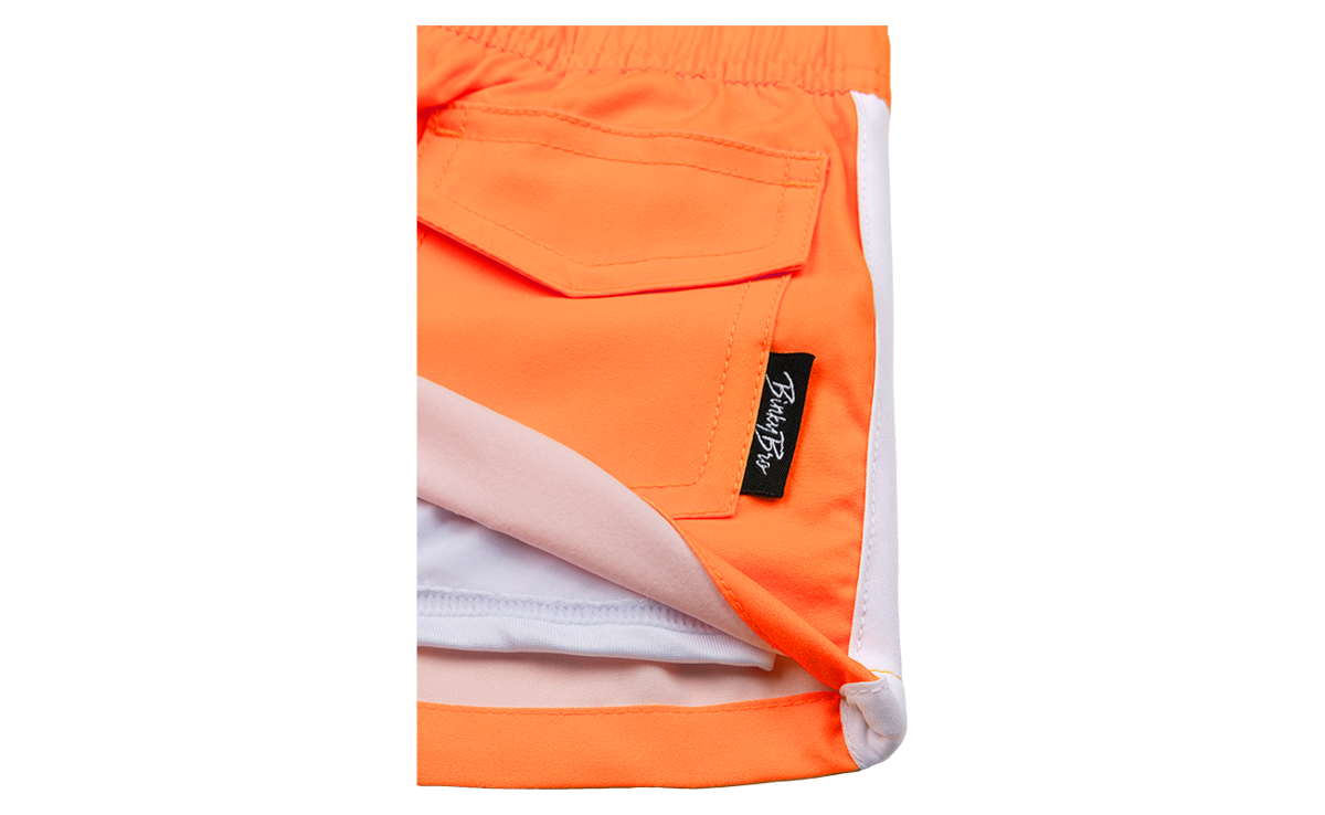 Close-up of Blaze Tangerine shorts featuring a vibrant orange color and a small BinkyBro label on the pocket.