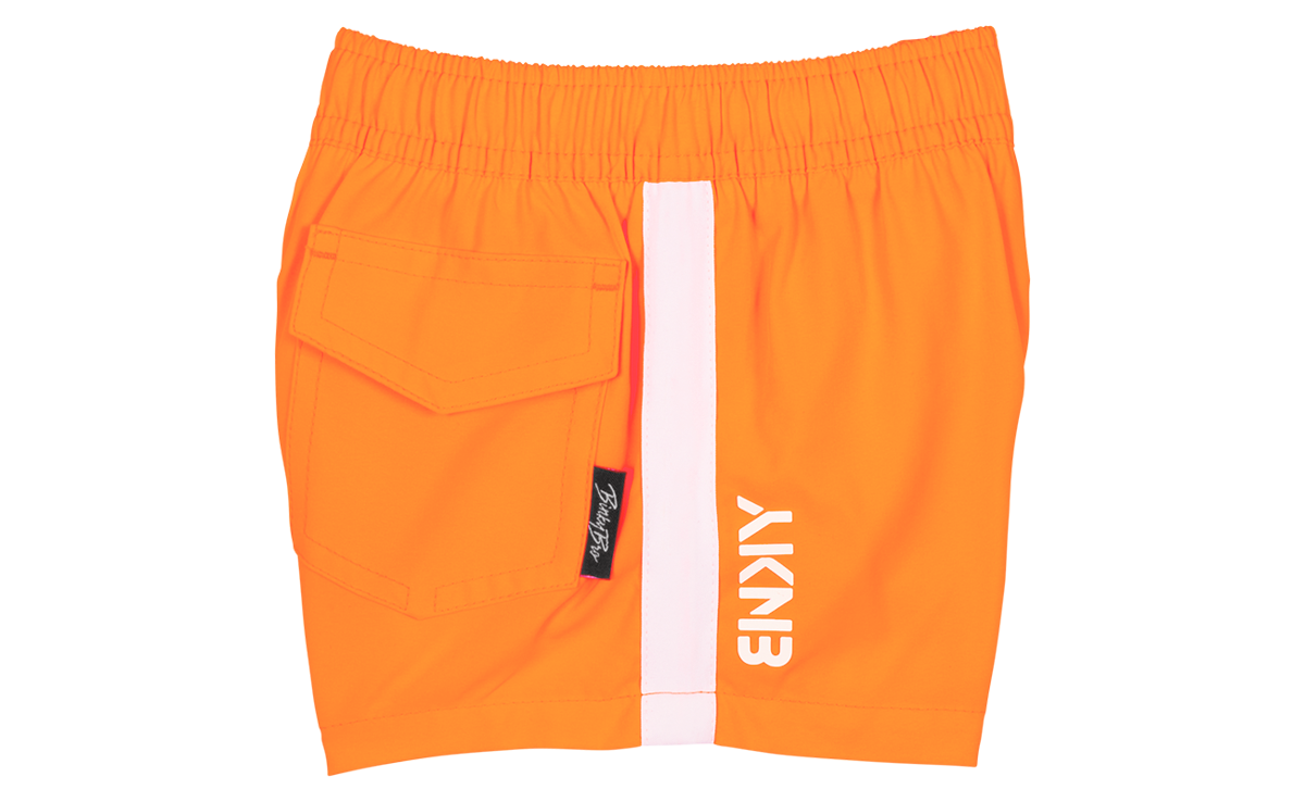 Bright orange shorts featuring an elastic waistband and a side pocket, designed for active kids with a stylish edge.