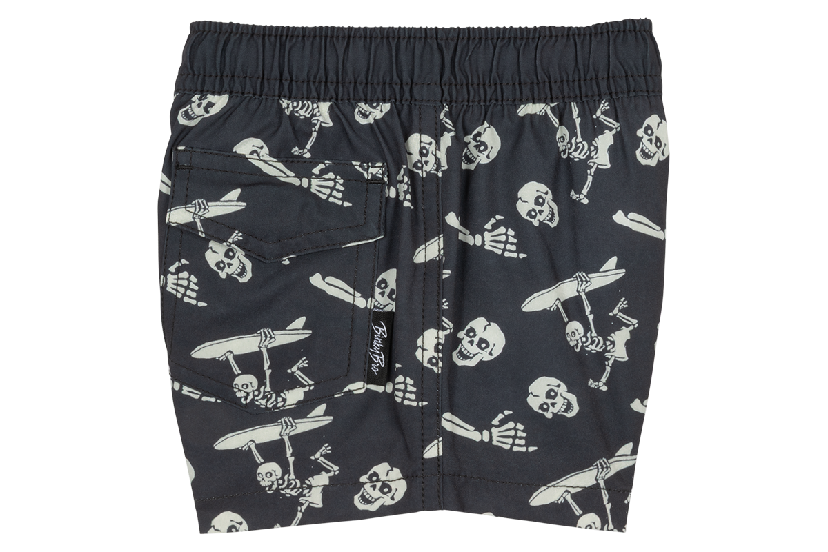 Stylish black swim shorts featuring a playful skeleton and surfboard print, perfect for kids' summer adventures.