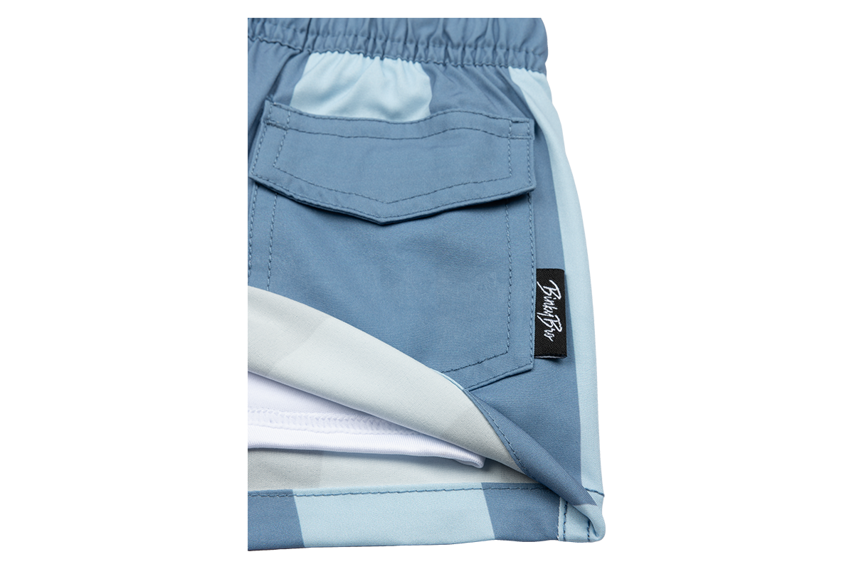 Stylish blue swim shorts featuring a pocket and BinkyBro label, perfect for kids' summer adventures.