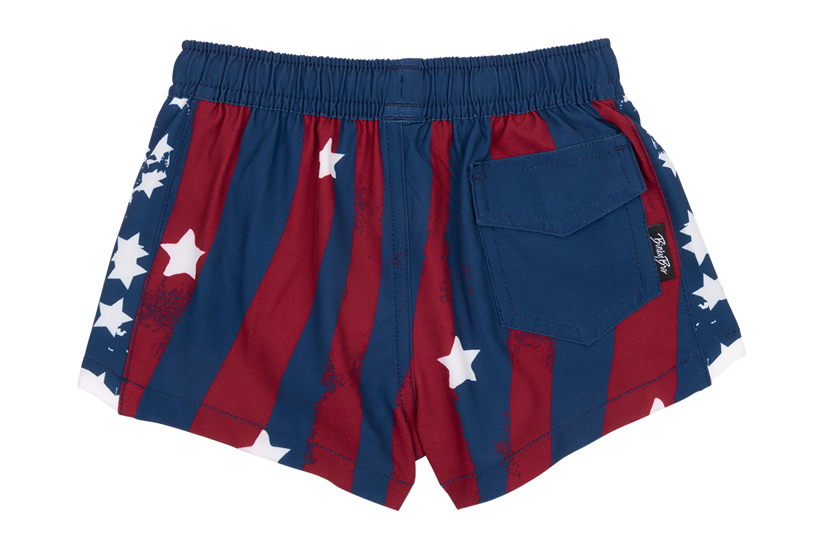 Red and blue swim shorts featuring a star-spangled design with white stars and a back pocket, perfect for summer fun.