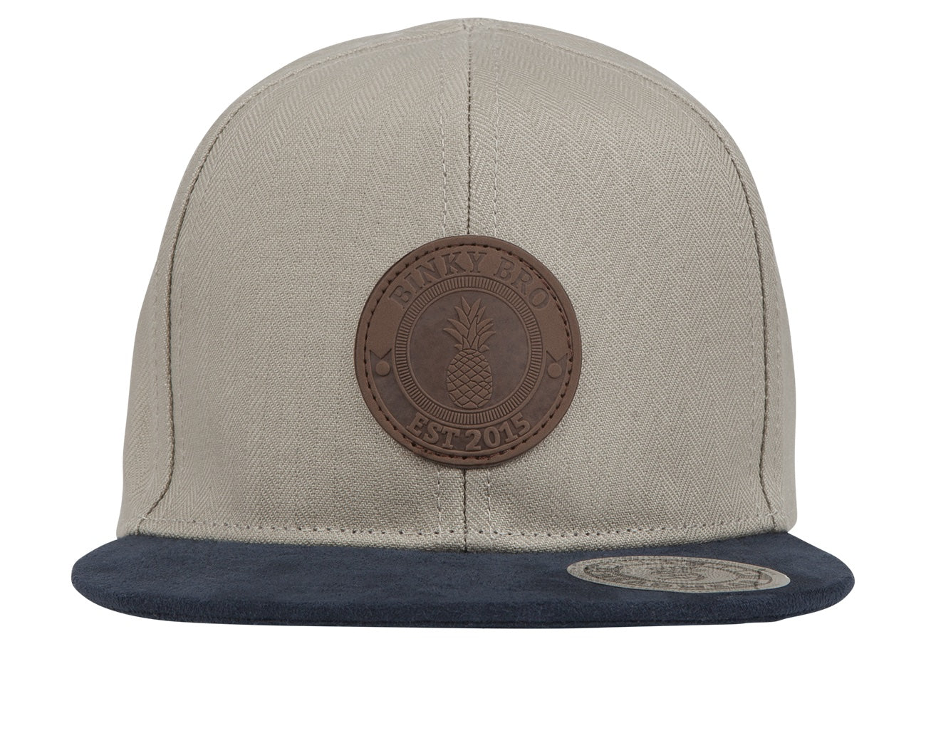 Stylish snapback hat featuring a beige herringbone pattern and a navy blue brim, with a leather logo patch.