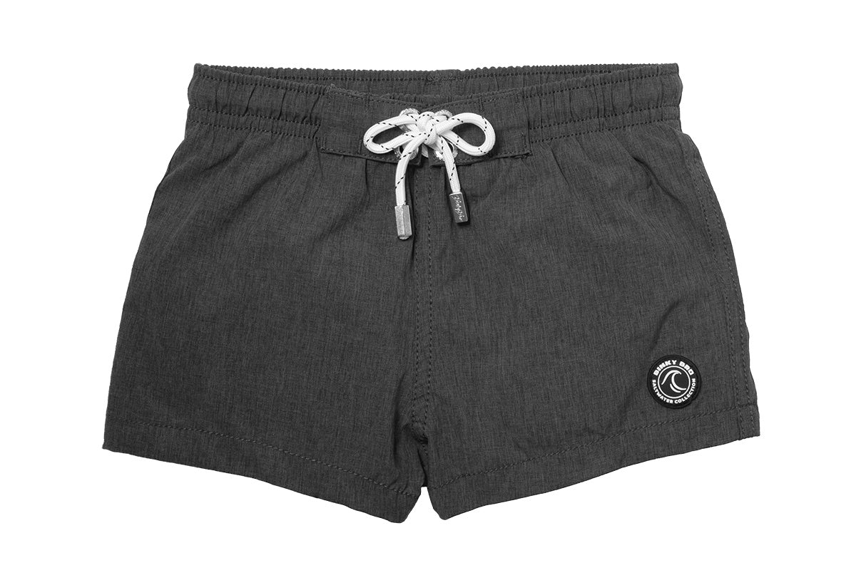 Stylish dark gray swim shorts with an elastic waistband and drawstring, featuring a logo patch on the side. Perfect for kids.