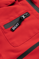 Close-up of a red BNKY Imperial jacket featuring a zippered pocket with a branded pull tab, showcasing stylish outdoor gear for kids.