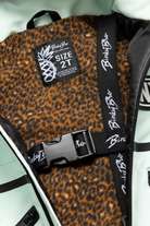 Dusty teal jacket interior featuring a leopard print lining and a branded strap, designed for toddlers.