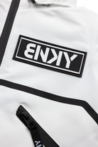 Close-up of the BNKY Stalactite jacket featuring a prominent black logo patch and sleek zipper detail on a white fabric.