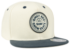 Stylish cream snapback hat with navy brim and Binky Bro surf-snow-skate logo, perfect for kids' outdoor adventures.