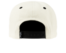 Back view of a cream snapback hat featuring black eyelets and an adjustable strap, designed for stylish youth wear.