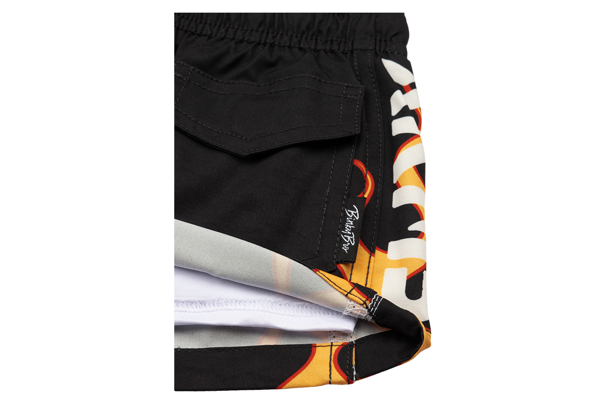 Stylish black swim trunks featuring a vibrant stamped flame design, perfect for kids who love surf and skate culture.